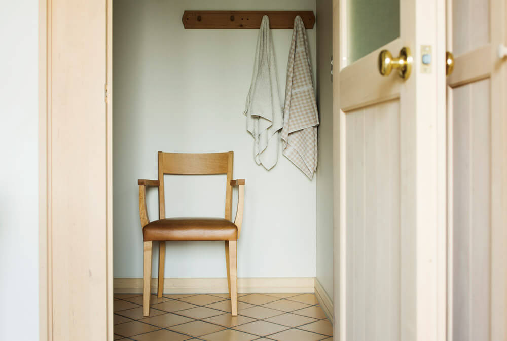 脱衣室の壁に取り付けられた木製フックには、自然素材を用いたシンプルなタオル