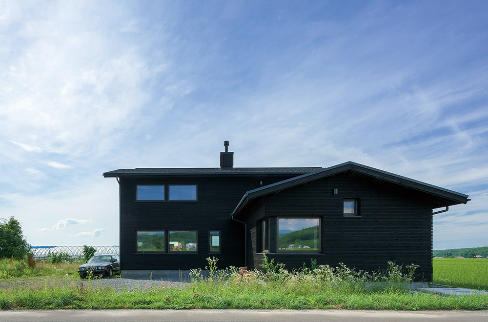 爽やかな風が渡る田園風景の中に建つYさんの住まいは、平屋と2階建てをL型に組み合わせた独立型の2世帯住宅