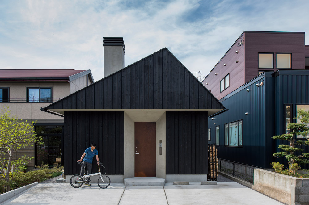 煙突と三角屋根が、住宅街にあってひときわ目を引く山小屋風の外観