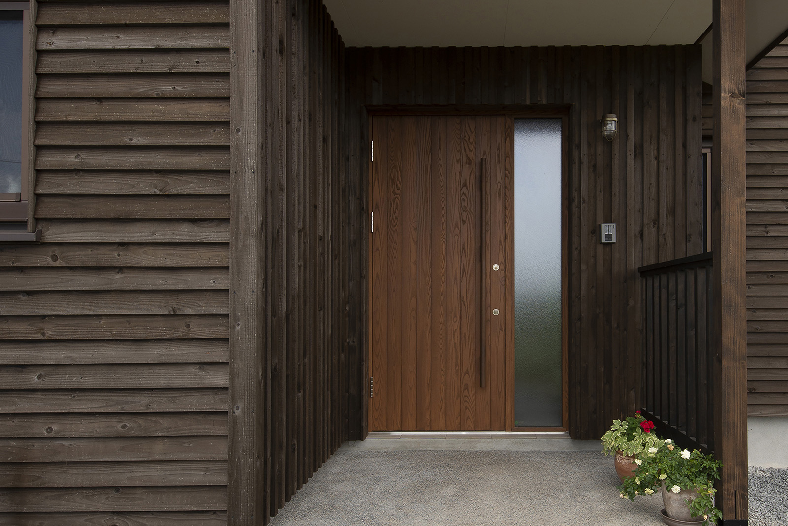 外壁に合わせて玄関も木製ドアを採用。外まわりには全面的に木質感を出している