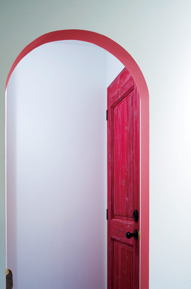 1階のRoom1にあるトイレの扉は、鮮やかなピンク色で遊び心を表現