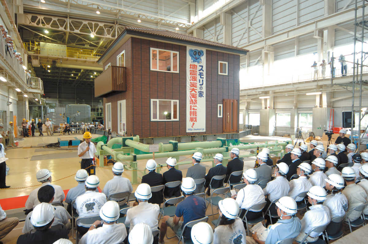 平成18年8月に茨城県つくば市の独立行政法人土木研究所で行われた、実際の家での耐震実験の様子。スモリの家は瓦1つ、レンガタイル1つ落下しないだけでなく、地震後も地震前とほぼ同じ耐久性能を備えるという実験結果が出た