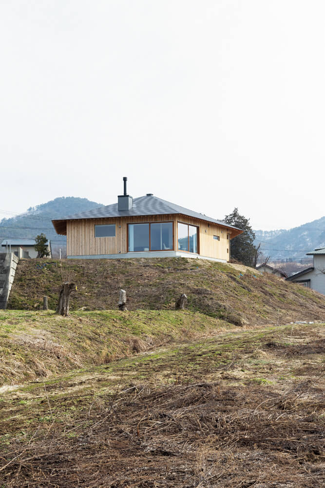 3棟分が建つほどの広さと盛土によって高低差のある敷地を生かし、山を望める方向に大きく開く配置計画とした