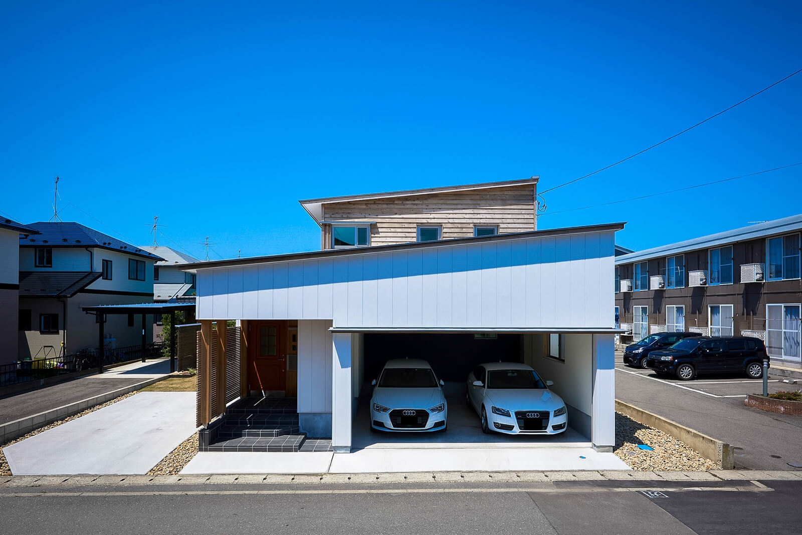 天井350㎜、壁225㎜、基礎断熱60㎜＋60㎜、付加断熱50㎜の家。車庫へ雨や雪に濡れずに行き来でき、除雪が最小限で済むように、屋根形状と動線を考えた。雪対策のため、雪止め雨樋を一切設置していない