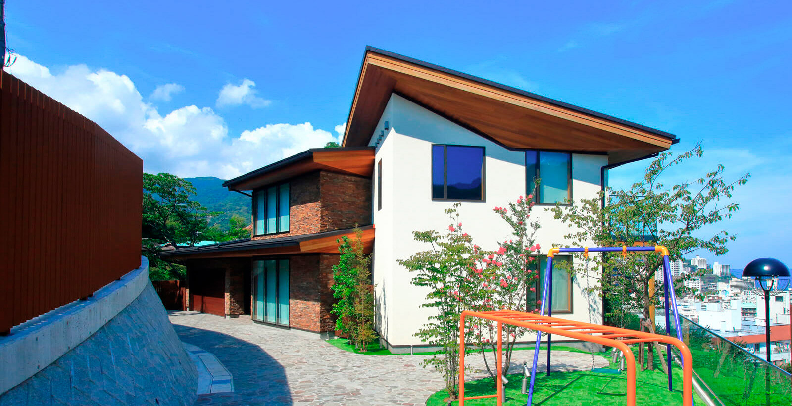 エントランスガーデンは美濃石乱形。外壁は割り肌の 石張りとジョリパットを使用。対比させることで石の重厚感を一層引き立たせている