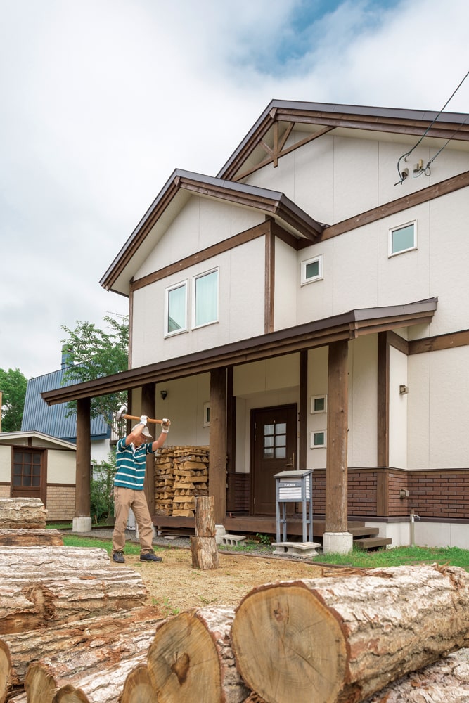 新築から8年経た住まいの前で、薪割りに精を出すUさん。今ではその手つきも、堂に入ったもの