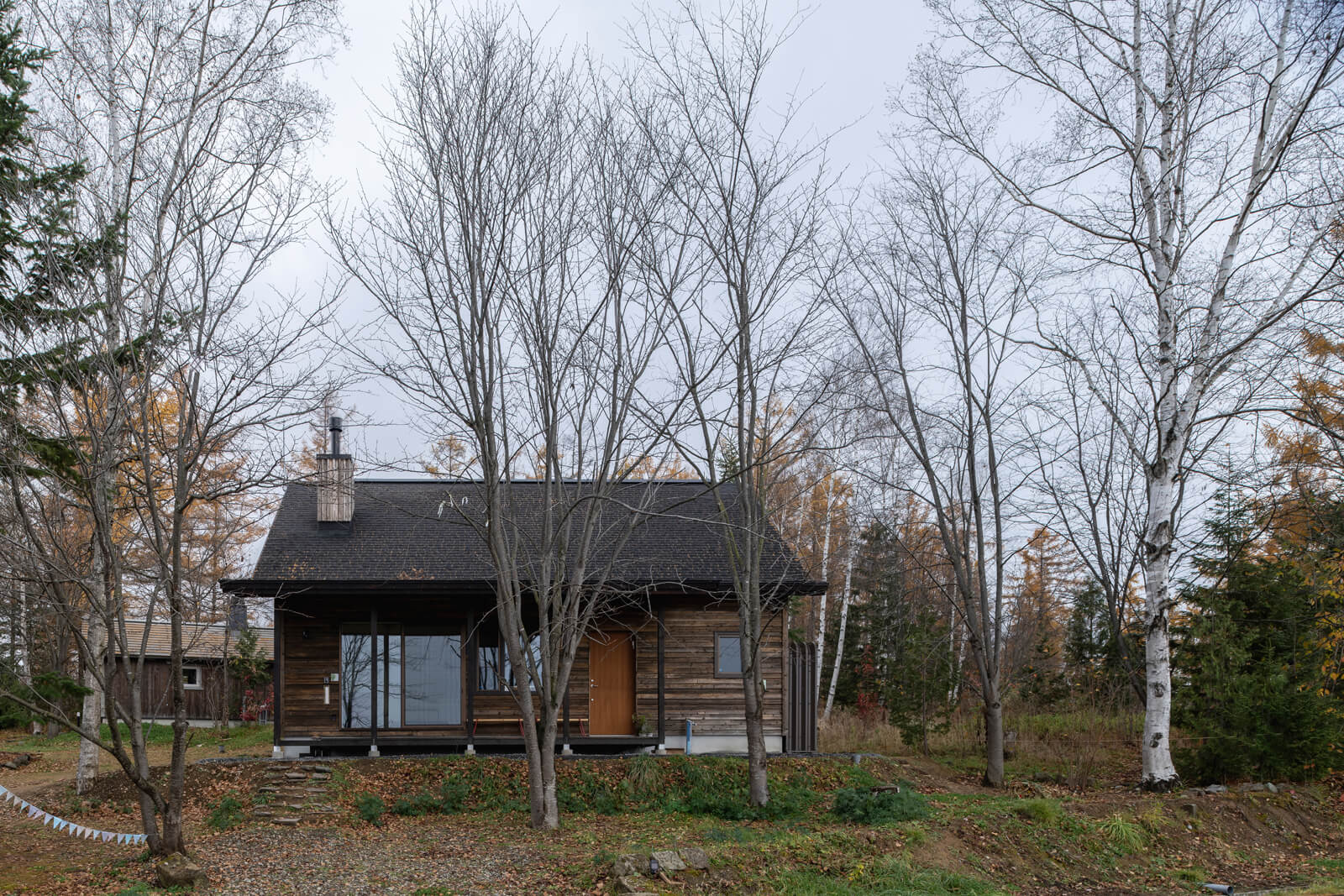 町の中でも、丘の景色と旭岳を眺望できる一等地に建っているSさん宅。広い庭から望むと森の中にひっそりと佇むような雰囲気