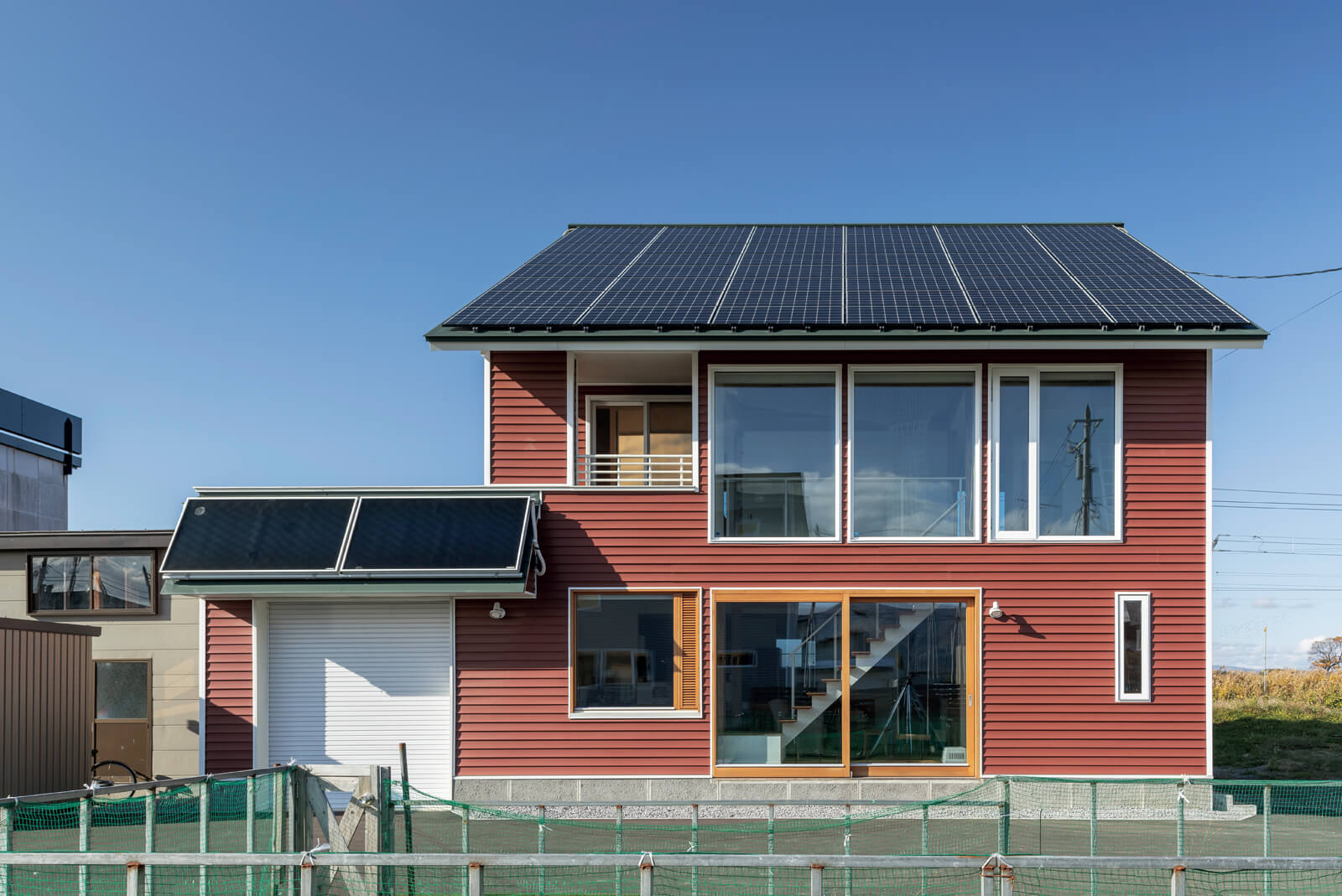 太陽光発電パネルを設置した、大きな開口を持つ片流れ屋根の家
