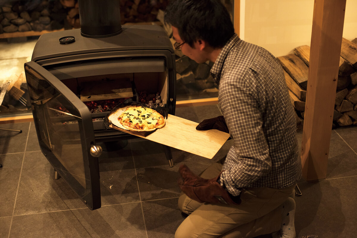 炉の大きなストーブなので、調理器具や料理を出し入れしやすい。熾き火になったらピザの入れ頃。数分で外はカリッと中はモッチリなピザが焼き上がる。おなかも心も満たされる至福の一時