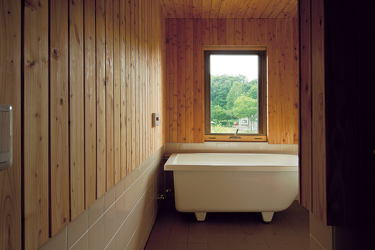 入浴しながら緑が眺められる浴室。この場所にも間仕切りはなく、目隠しのカーテンのみ