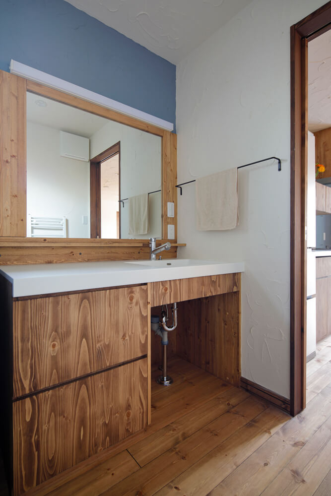 1200㎜幅の広い造作洗面台に合わせた1000㎜幅の鏡。キッチン同様、木目が美しく合う丁寧な仕事が伝わる