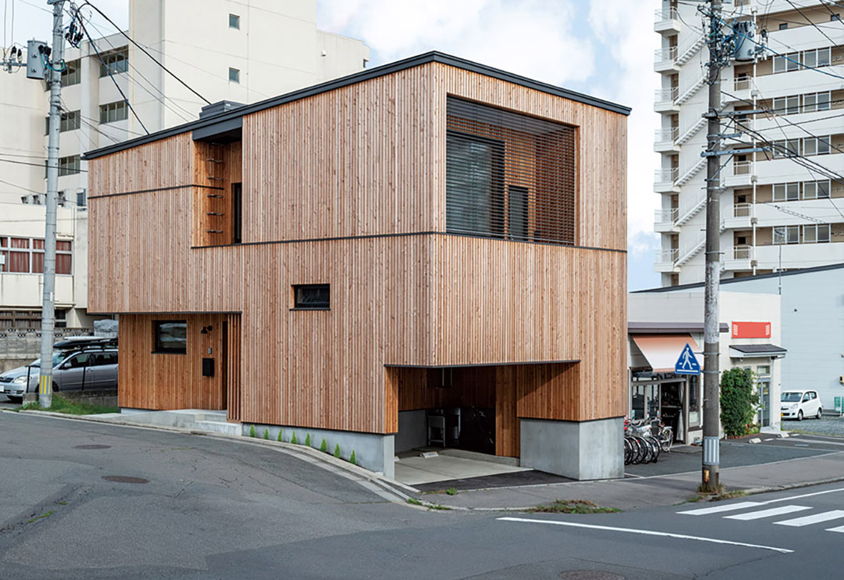 街なかの狭小地ゆえ、駐車場や玄関ポーチ、バルコニー等の屋外機能空間は、緩勾配の屋根を載せた直方体からそれぞれ引き算することで外観を構成