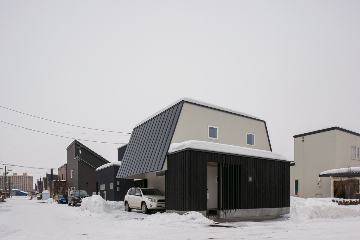 屋根らしい屋根が欲しいというご主人の希望を受けてデザインされた、昔ながらの三角屋根をなぞらえた外観は、懐かしくも新しい印象でご近所からも好評。南北に伸びる軒下は駐車場や縁側を雪から庇う役割を持つ