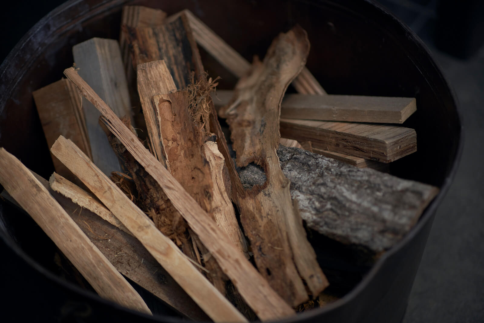 薪ストーブの横に置かれた大きなバケツには、種火用の細かい木片をストック