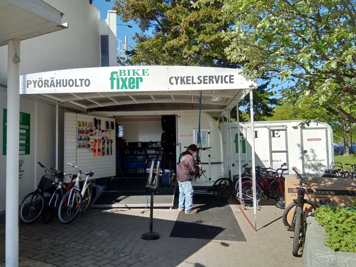 人気カフェのメインエントランスの隣にある、自転車修理の専門店