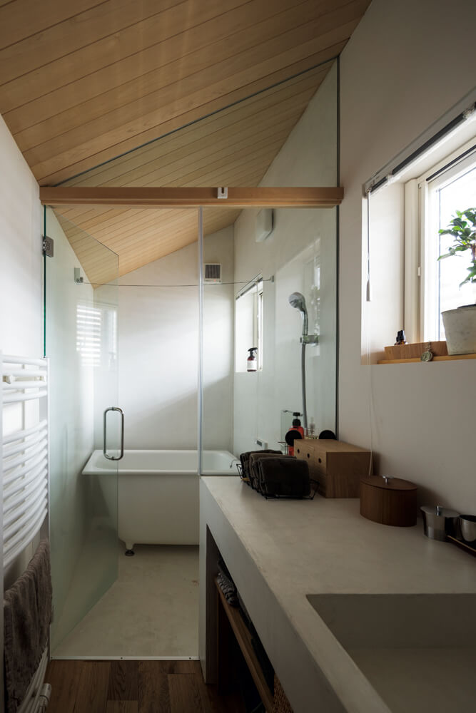 モールテックスで造作された一体型の洗面台と浴室。天井は青森ヒバ。浴槽は奥さん憧れの置き型のバスタブを採用