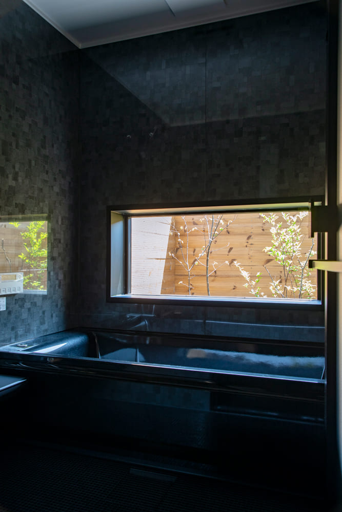 浴室もオールブラックでコーディネート。大きめの窓からはプライベートな庭を望むことができる