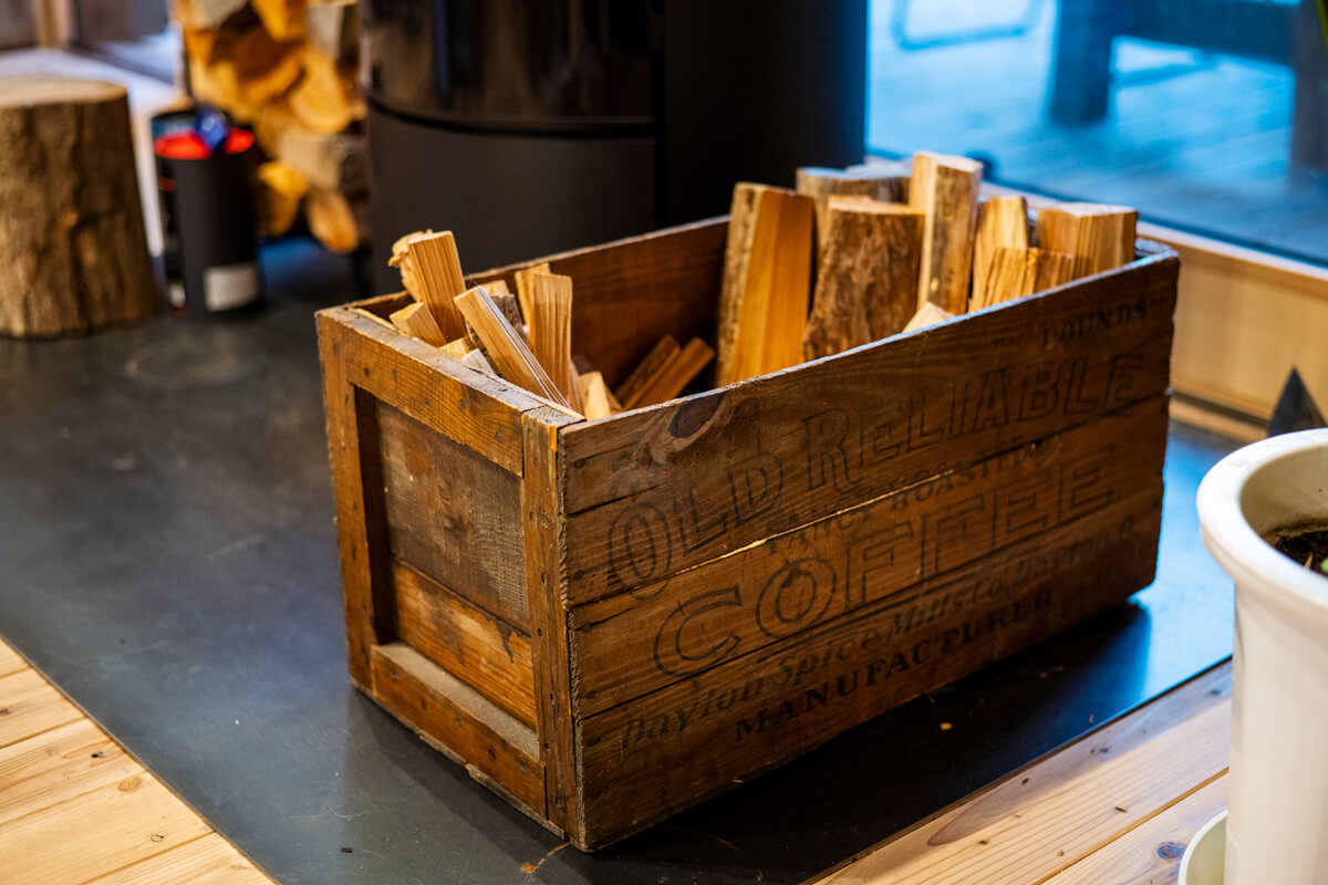 ヴィンテージアイテムが好きだというYさんのコレクションの一つである木箱を薪置きに活用