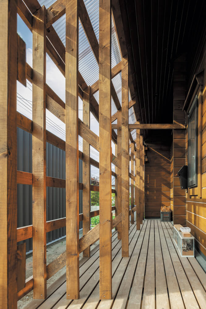 大屋根の深い軒の出を利用した玄関へのアプローチは、薪置き場を兼ねた設計。雨を防げて風通しが良く、薪の乾燥に絶好の環境