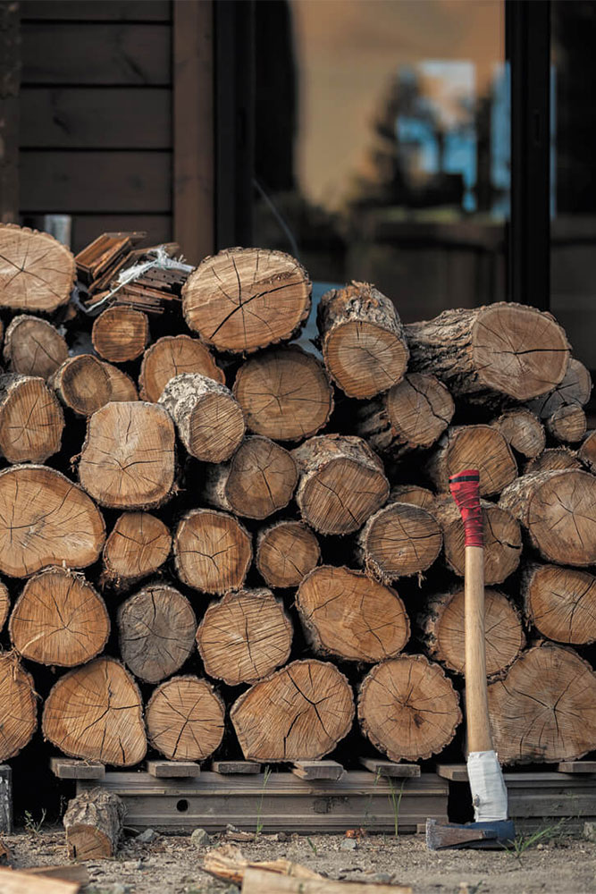 薪の大部分は近隣の果樹園の伐採木だが、専門店から購入したナラ材もストック。これを自らの手で割って薪棚に積み、冬に備える