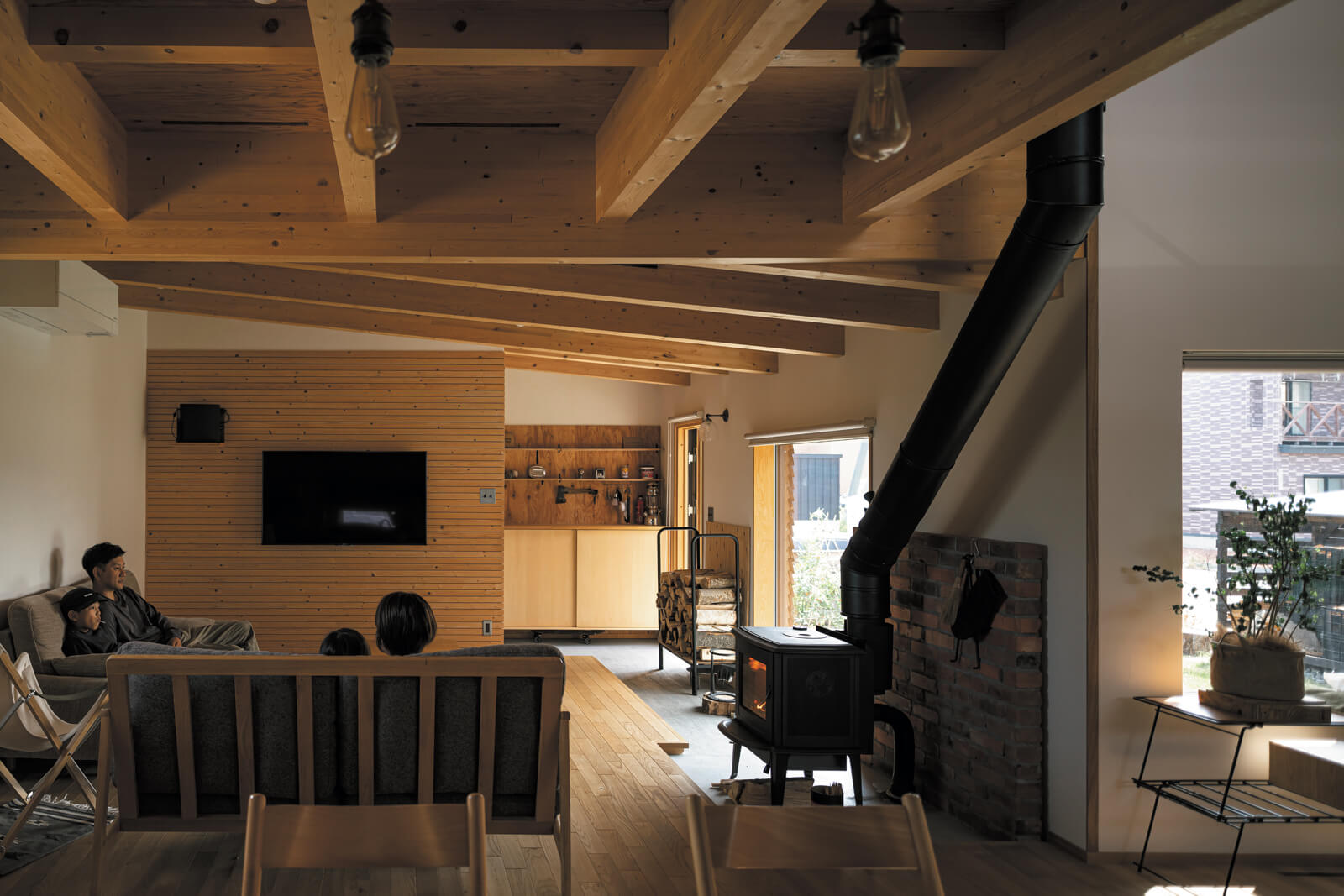 合板の現し天井や無垢床など、木質感のある室内空間に「ロッジ風になりすぎないデザインが、私たちの薪ストーブのある家の理想そのもの」と奥さんは笑顔