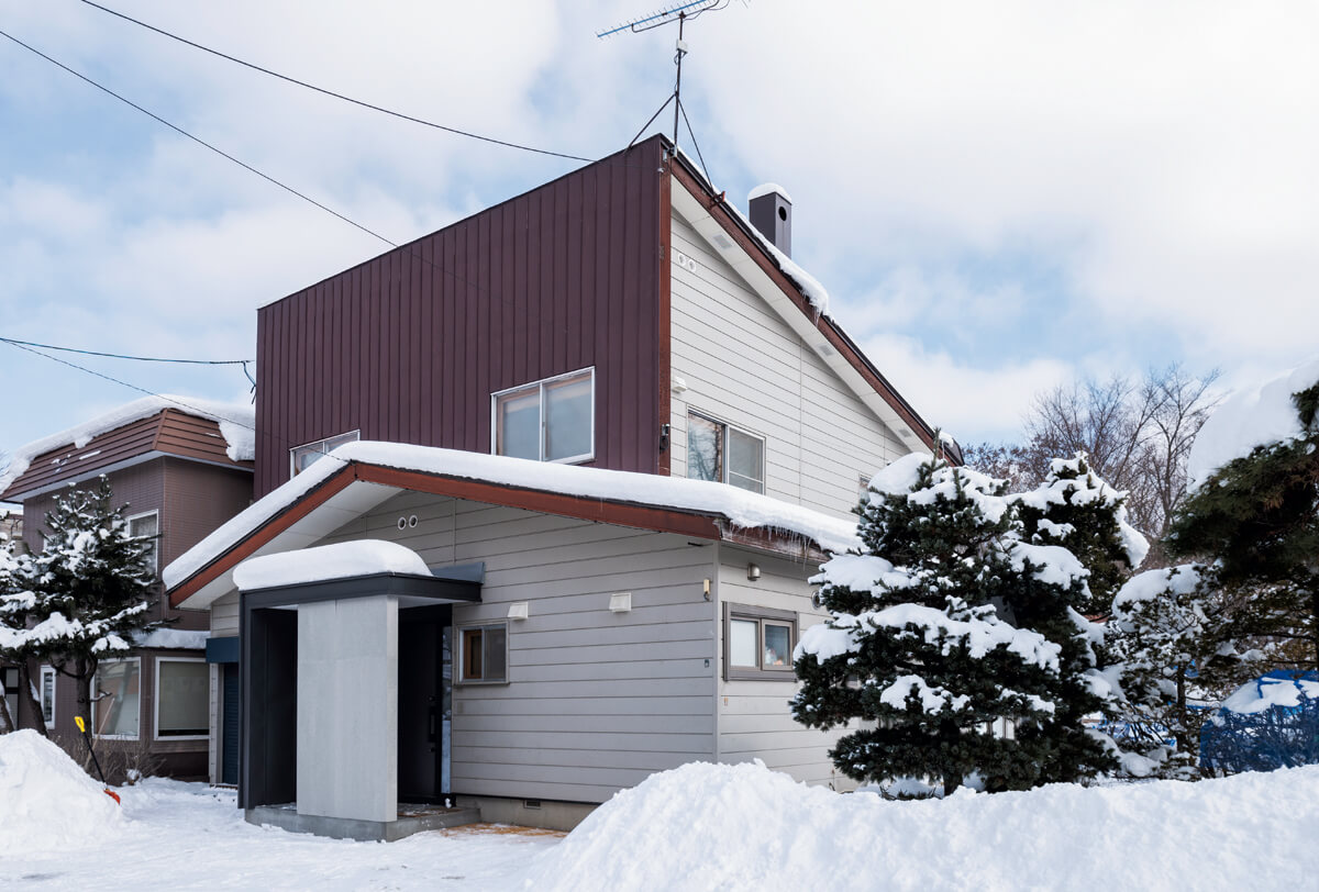 既存のフォルムはそのまま生かしたYさん宅の外観。雪解け後に玄関ポーチの未造作部分の左官仕上げ、枕木を採用した外構を設える予定