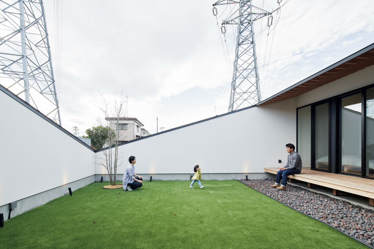 中庭を囲む塀が空を大きく切り取って、住まいと中庭のプライベート感を高めている。隣地は電力会社の敷地で、これから先も住宅や高い建物が立つ心配がなく、広い空が見える住環境を維持できる