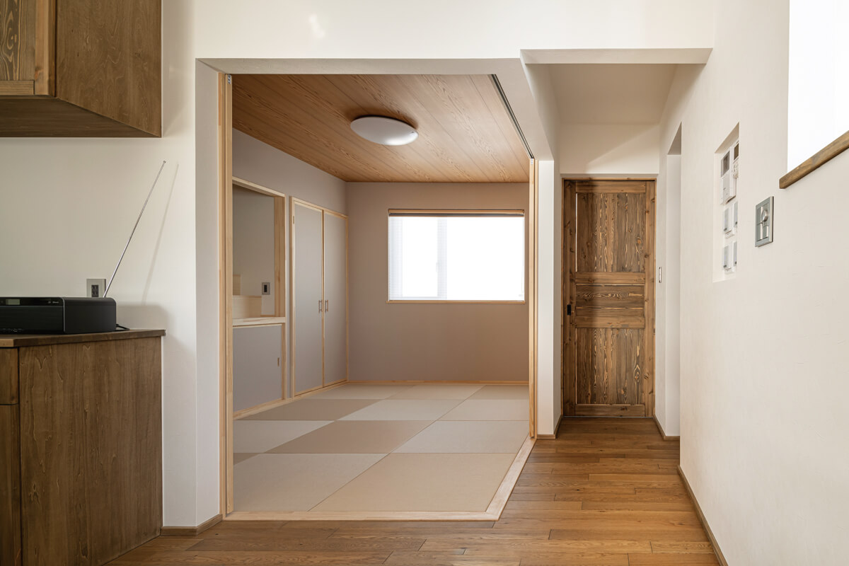 琉球畳を採用し、すっきりとシンプルに仕上げた和室は、開け放していてもリビング・ダイニングに違和感なく溶け込む。来客時には、造作障子を閉めて独立した空間にできる