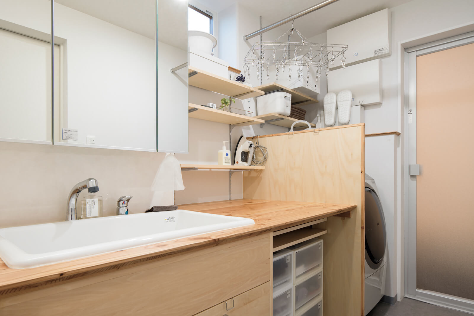ユーティリティの造作洗面台は、家事台と一体型。スムーズな動線で動けて、アイロンかけや衣類を畳むのに便利