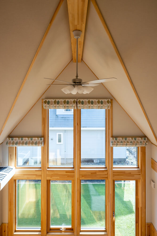 特徴的な屋根形状がよく分かる吹き抜け部分。リズミカルな天井の形とシンメトリーな窓が美しい