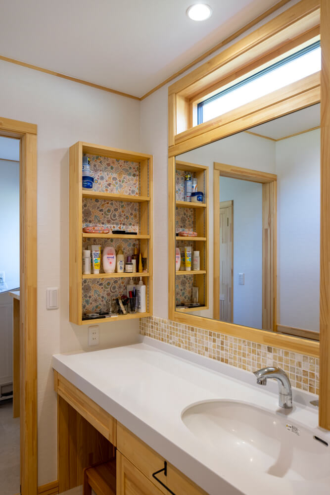 木を使った造作洗面台には横長の大きな鏡が。彩り豊かなモザイクタイルで遊び心をプラス