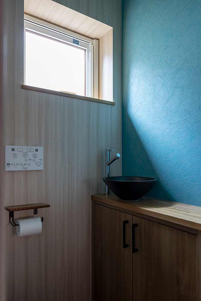 ブルーの壁がアクセントになっている爽やかなトイレ