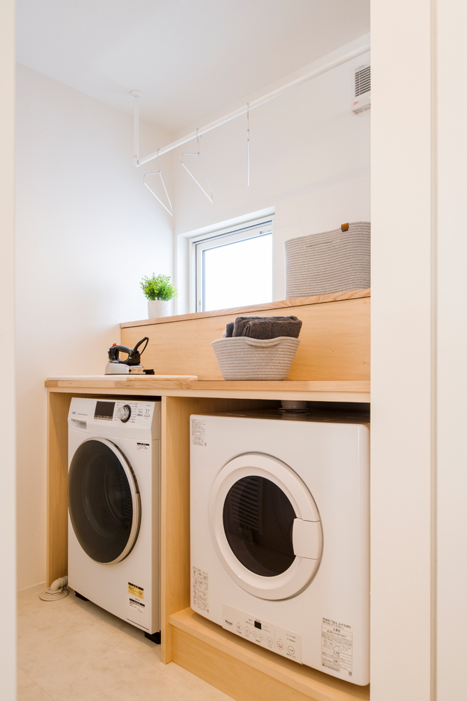 ランドリールームは洗濯機とガス乾燥機を横並びに配置。上部はアイロンがけや洗濯物を畳むのに便利なカウンターとして活用