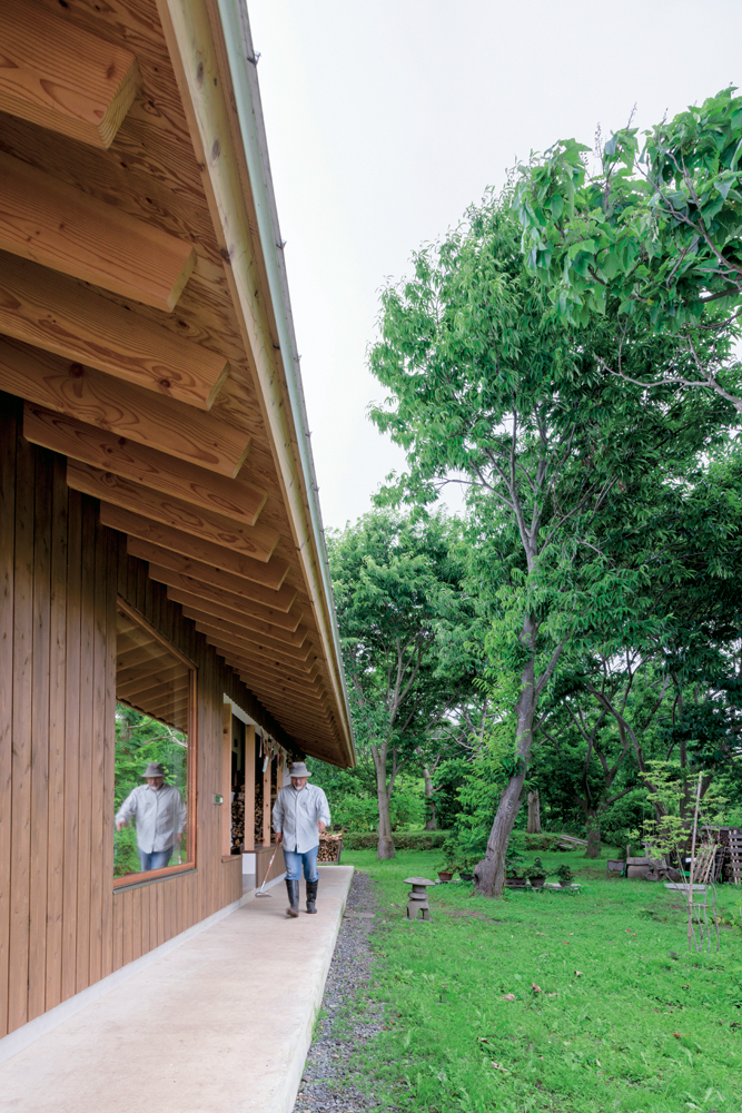 玄関のある建物の北側。建物奥には畑道具などを 収納する倉庫があり、その手前には薪置き場がある