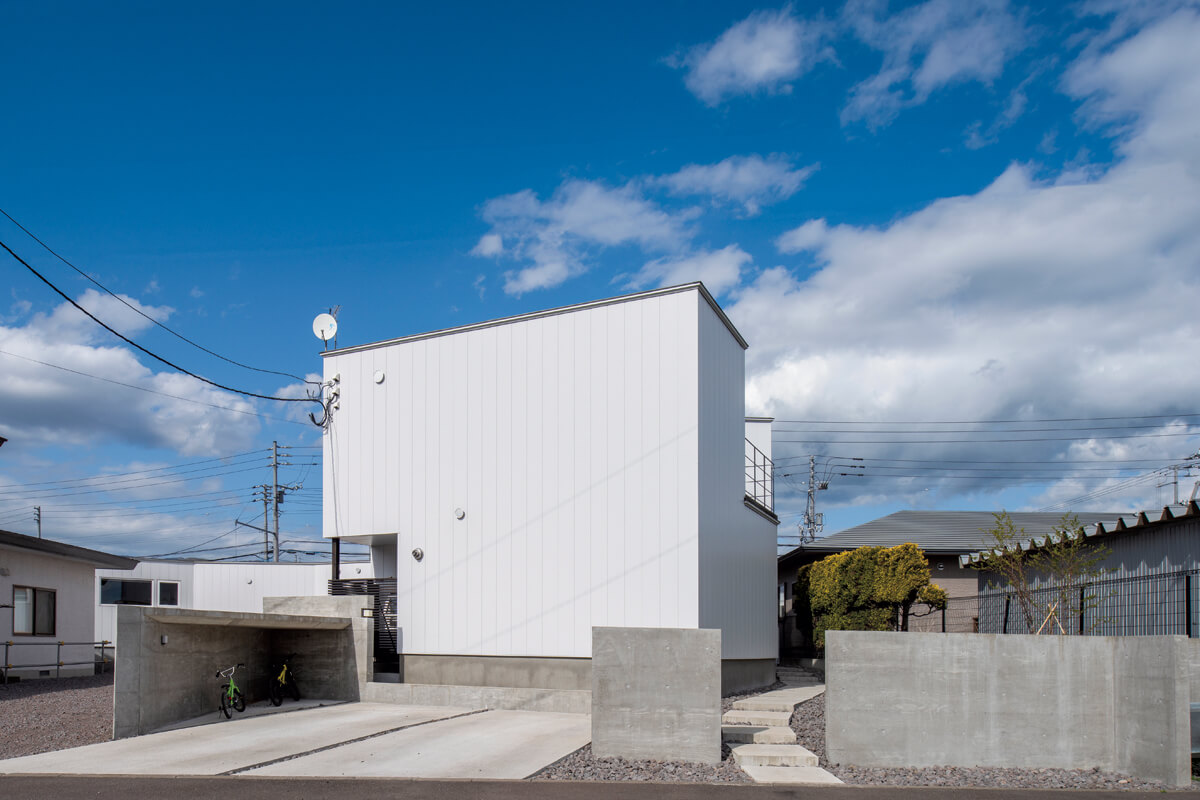 2階建ての住居部分は、プライバシーに配慮して主道路から見て奥、住宅街の中の道路沿いに配置。デザイン性とコストを検討し、外壁には金属サイディングを採用した