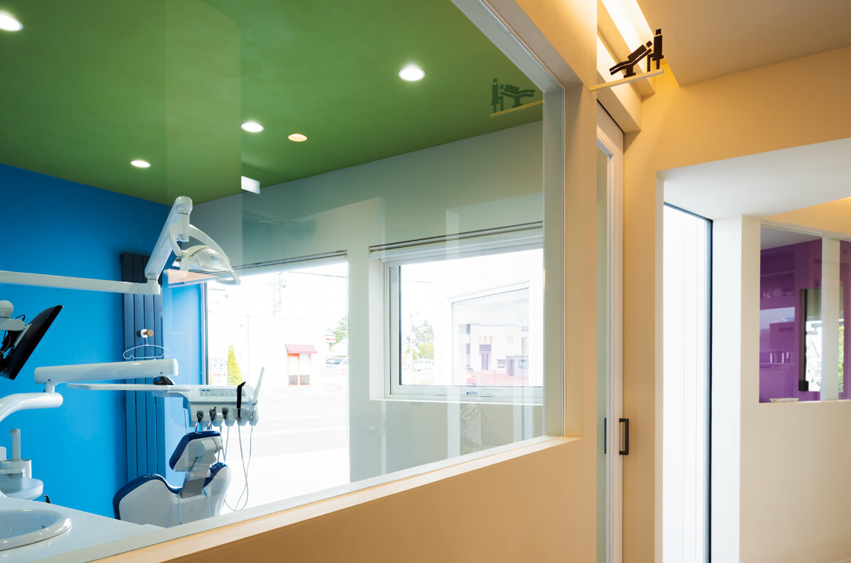 診察スペースおよび診察室はそれぞれ、出入り口上に付けたサインと壁の色で差別化。サインは、このクリニックのために建築家が知人のデザイナーと考案したもの
