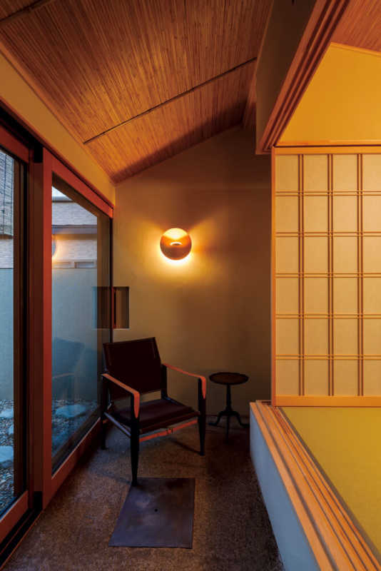 京都の老舗名旅館のとある一室の魅力をぎゅっと凝縮して表現したという和室。陶板を敷いた三和土や飛び石のある坪庭含め、細部にまで伝統文化へのリスペクトがありつつ、照明やモダンな家具が溶け込んでいる