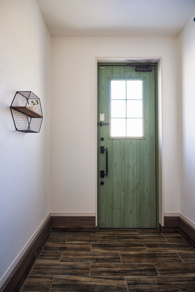 すっきりとした玄関。三和土には玄関ポーチと同じ木調タイルが敷き詰められている