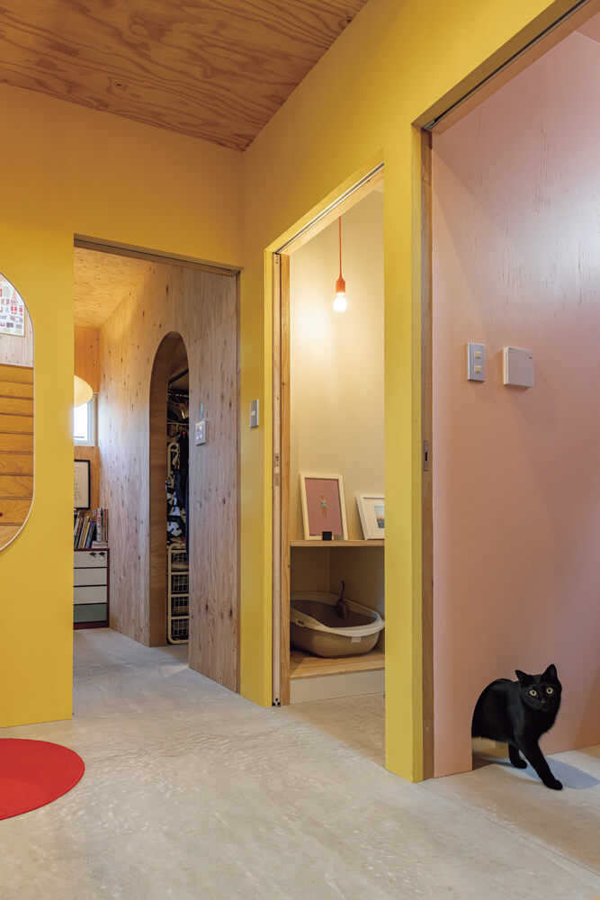 玄関に入って左手に寝室。家族が使うトイレには、猫用トイレのスペースを併設した。洗面・脱衣室の壁の小さな穴を通って、猫たちは自由に行き来できる