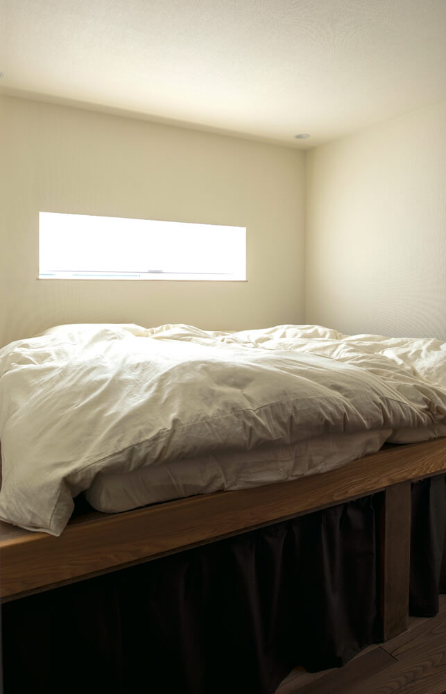 1階の寝室は寝ぼけて落下するのを防ぐためにベッドの両端を壁つけにしてもらい、下部を収納としている