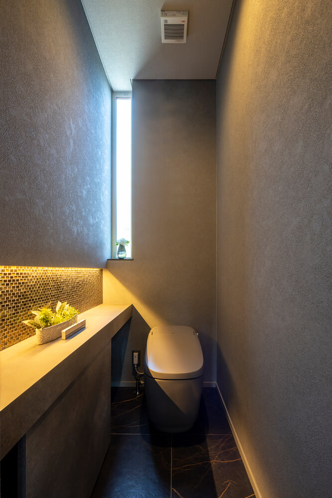 ガラスのタイルを配したトイレは、クラシカルな表情をした床材で上質な雰囲気に