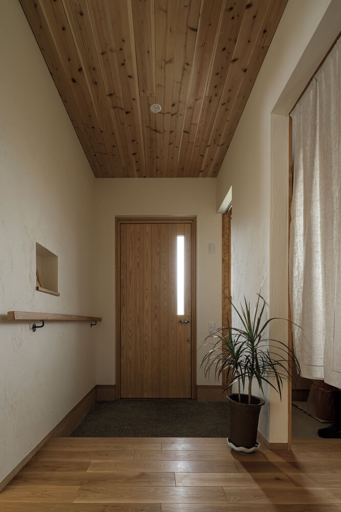 玄関は木板張りの天井と土間で雰囲気よく。シューズクロークを設置していつもスッキリを保てる