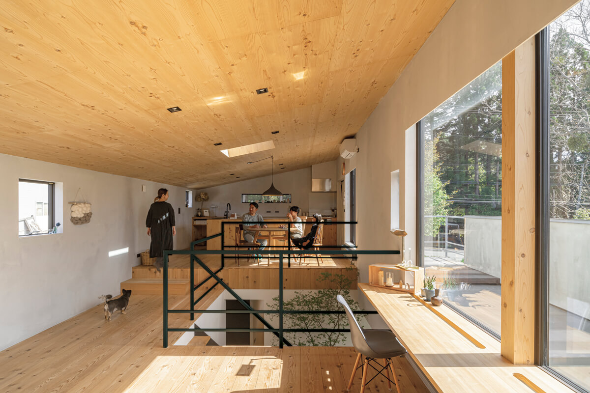 2階LDKは勾配天井の大空間。リビングとダイニング・キッチンはスキップフロアでつながり、ダイニングの掃き出し窓からは広いテラスに出られる。面材を木で仕上げたキッチンは造作で、この空間に合わせてデザインされたもの