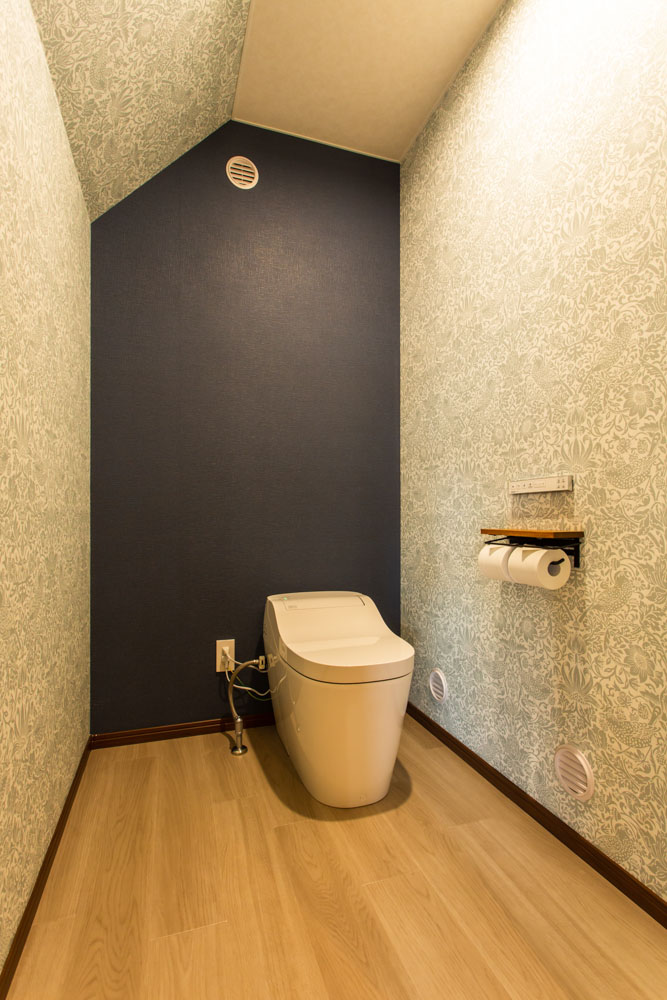 玄関ホールの右手に位置するトイレ。お気に入りのデザインクロスで彩りを