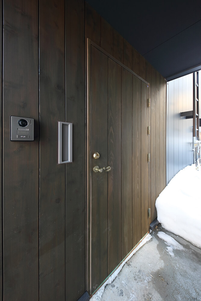 雨風や雪を防いでくれる玄関ポーチ。外壁の木質感が風合いを与えている