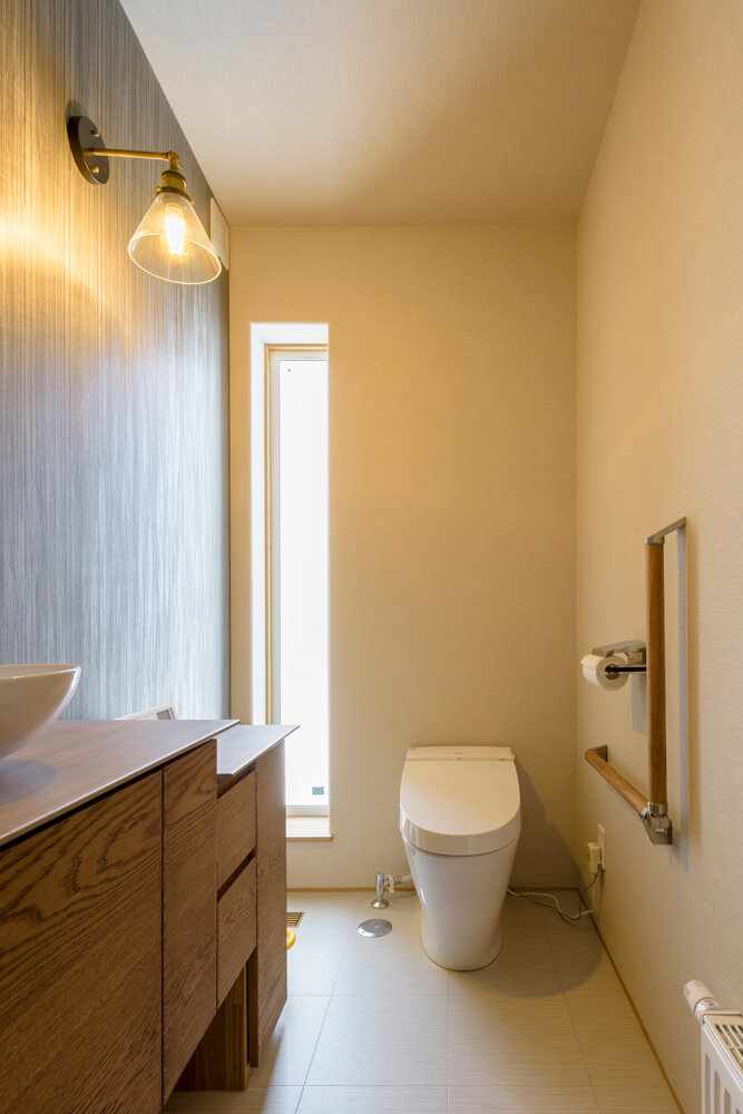 造作収納付き手洗いカウンターを設けた1階のトイレ。採光窓からの光が心地よい
