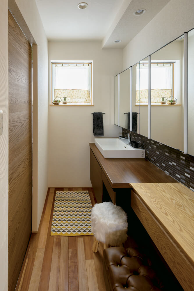 造作仕上げの洗面室はユーティリティと分離。壁に張った名古屋モザイクのタイルはキッチンにも採用したご夫妻のお気に入り