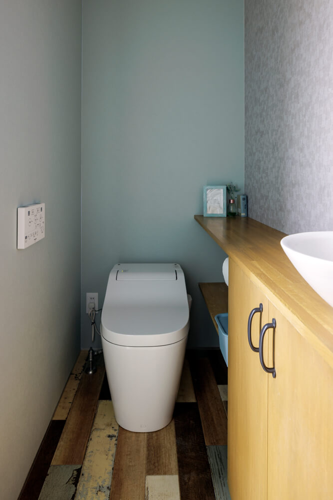 トイレの床はミックスウッドのクッションフロア。くすんだブルーグレーの壁紙と合わせビンテージな雰囲気