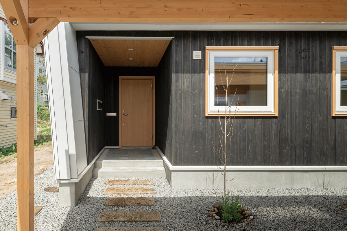 ナチュラルパイン・道南スギ・札幌軟石の敷石と素材感を楽しめる玄関アプローチ
