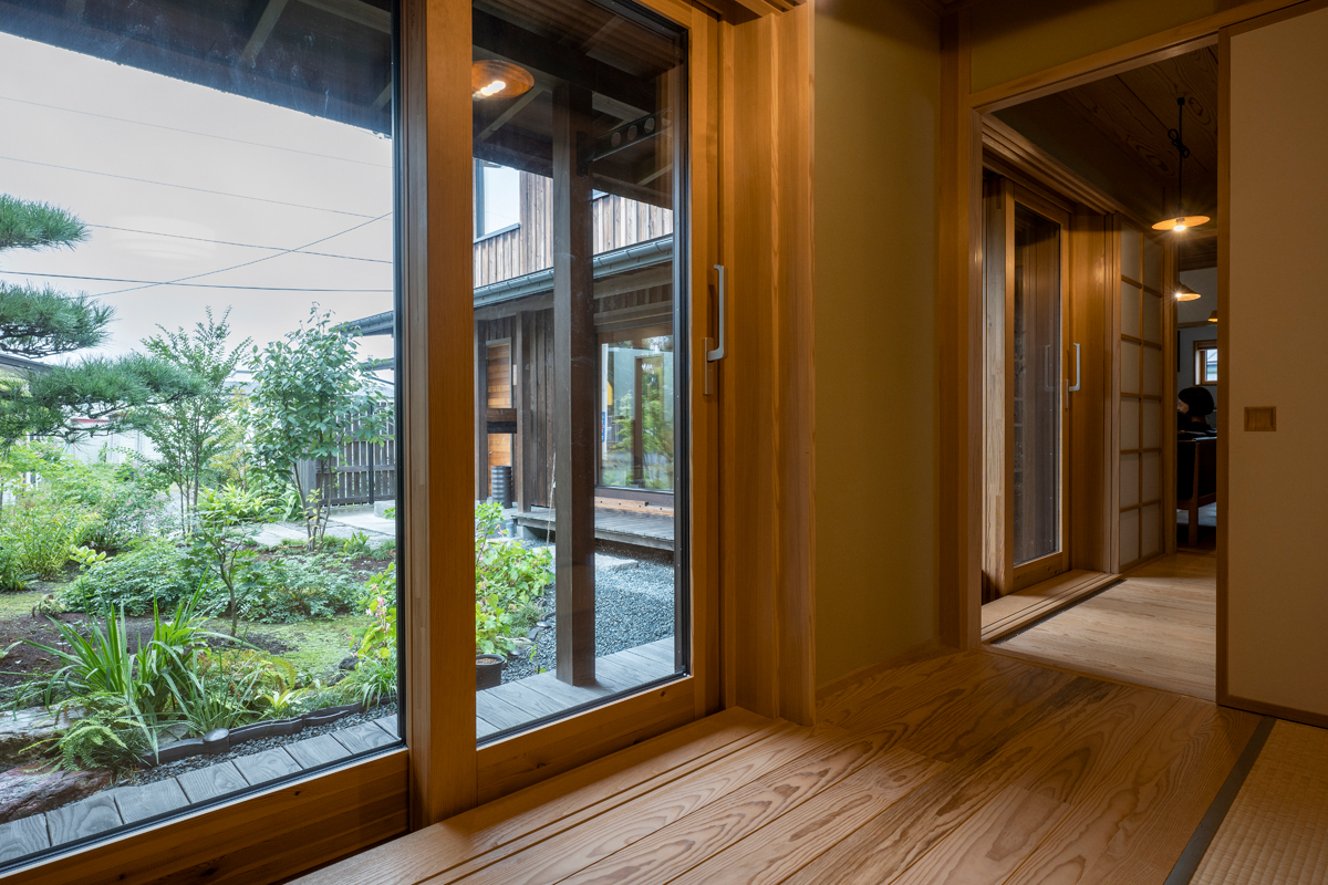和室に面した廊下の先に庭が広がる。室内の雰囲気に合わせ、木製サッシを採用しているのもポイントだ